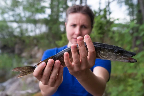 Ung upphetsad kvinna som fiskar gädda utomhus — Stockfoto