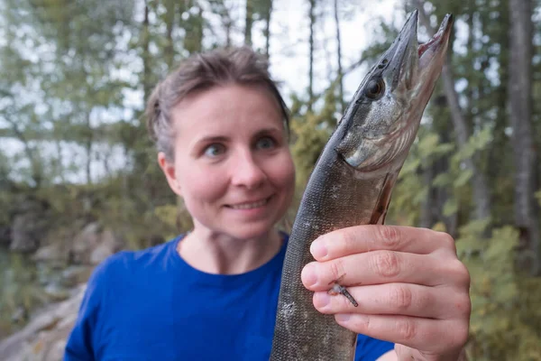 Ung upphetsad kvinna som fiskar gädda utomhus — Stockfoto