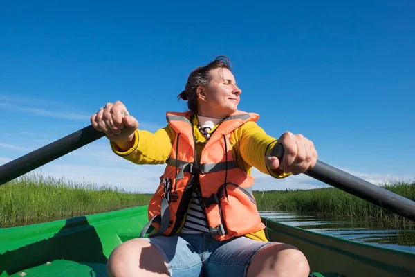 Frau paddelt an sonnigem Tag mit Boot durch den Fluss — Stockfoto