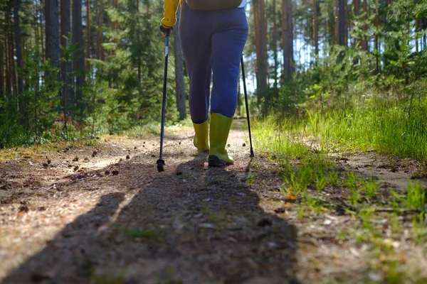 Beine und Nordic Walking Stöcke in der sommerlichen Natur. — Stockfoto