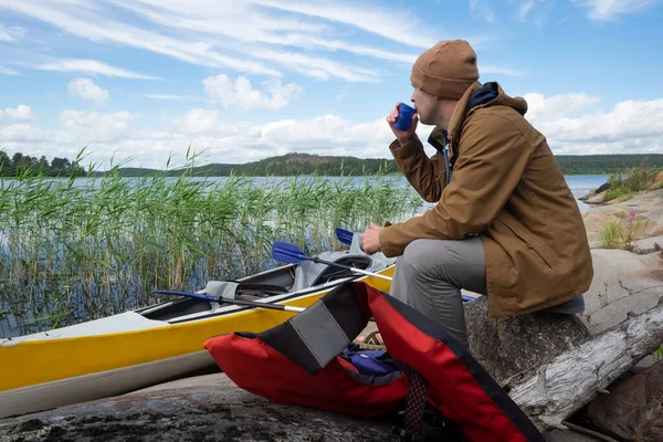 Mannen som sitter på flodstranden och vilar efter aktiv paddling — Stockfoto