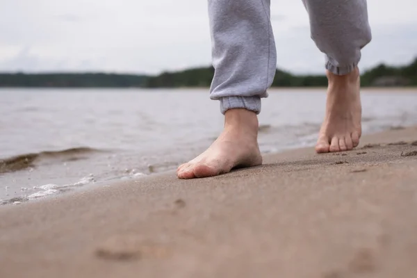 Мужские ноги босиком на песчаном пляже в воде . — стоковое фото