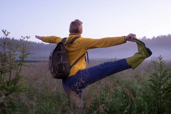 Jovem fêmea de pé na mão para pose dedo grande do pé praticando ioga no gramado — Fotografia de Stock