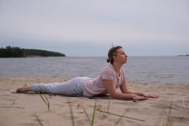 Yoga minderi üzerinde Kobra Yogası yapan Kadın