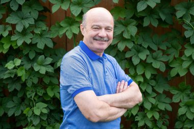 Mutlu yaşlı yaşlı adam dışarıda gülümsüyor..