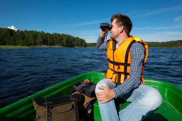 Mannen i båten tittar i kikaren — Stockfoto