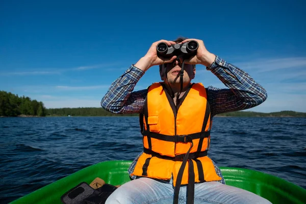 Mann im Boot blickt ins Fernglas — Stockfoto