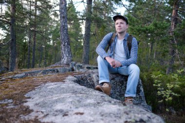 Yakışıklı adam ormanda yürüyor, tatilin tadını çıkarıyor..