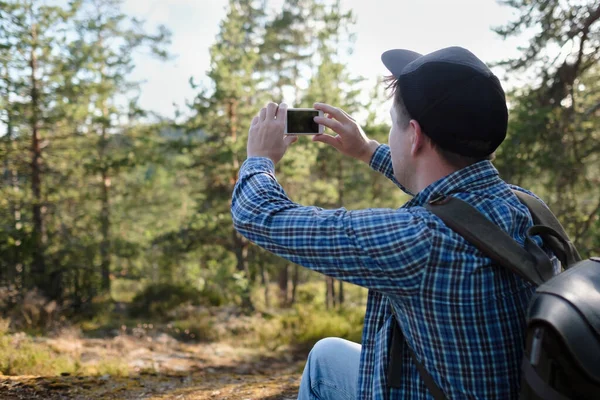 Mann macht beim Wandern Fotos mit Smartphone im Wald — Stockfoto