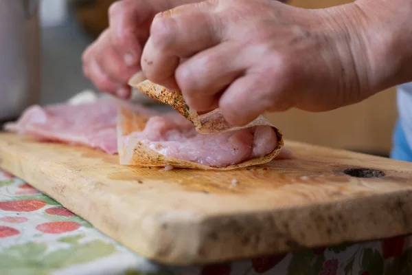 Kobieta ręce dodając kilka przypraw na stekach mięsnych na drewnianej desce. — Zdjęcie stockowe