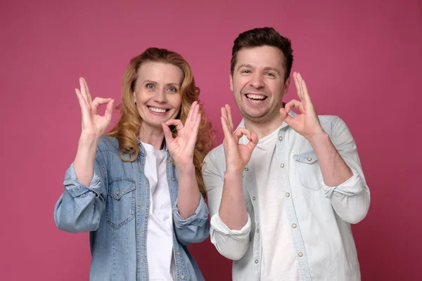 Beau sourire homme et femme montrant OK signe avec deux mains. — Photo