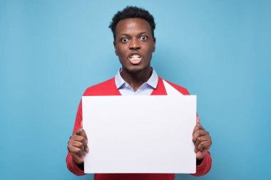 Elinde boş pankartlar tutan Afrikalı genç adam mavi arka planda hakları için savaşıyor. Eylemcilik, aktif vatandaşlık, sosyal yaşam, protesto, insan hakları kavramı.