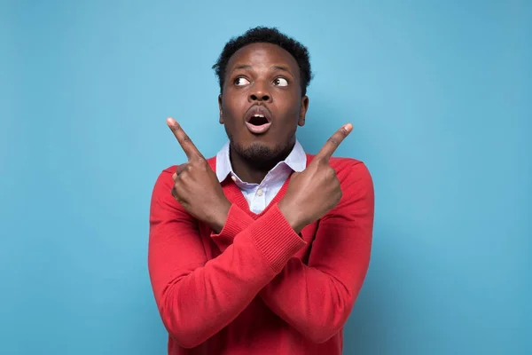 Young African Man Points Sideways Trying Choose Two Options Studio — Stock Photo, Image