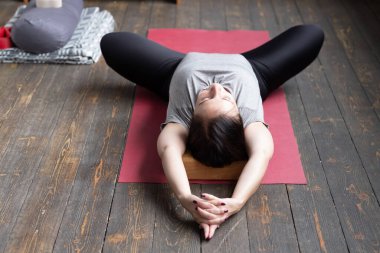 Yaslanmış Kelebek egzersizinde yoga yapan kadın, sanırım baddha konasana