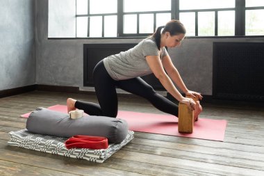 Kadın gerinme egzersizi yapıyor sahne donanımı, blok, Ardha Hanumanasana