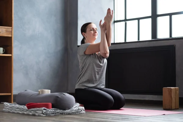 Caucasian woman at room with her crossed arms performing yoga exercise. — Stock Photo, Image