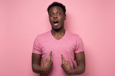 Adam kameraya bakıp kendini gösterirken elleri şaşkın.