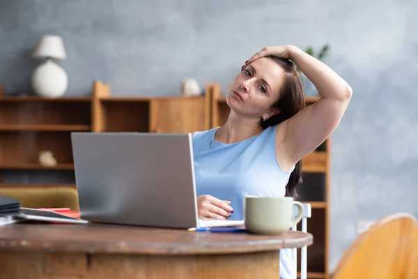 Young caucasian woman stretching side of neck muscle during work break at home — Stock Photo, Image