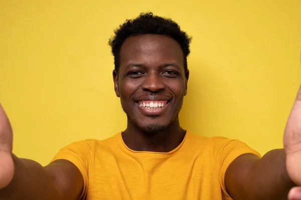 Sonriente joven africano haciendo selfie sobre fondo amarillo — Foto de Stock