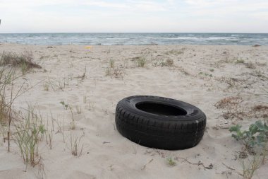Sahile atılmış otomobil lastiği