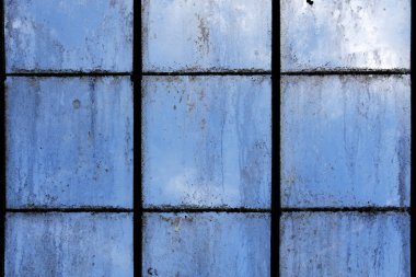 Dirty old greenhouse windows with a blue sky background clipart