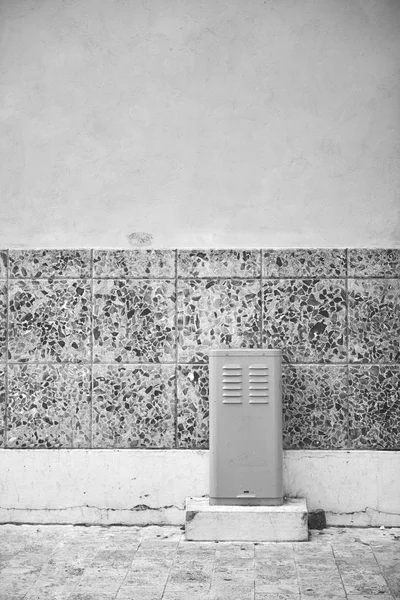 Picture of old transformer box in Santo Domingo the capital of Dominican Republic. Box is painted grey and is situated against the old facade of big building in Colonial Zone of the city.