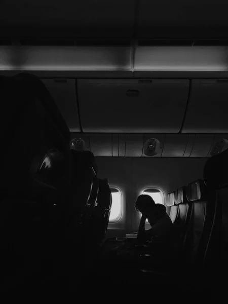 Hombre sentado contra la ventana en el avión y libro de lectura —  Fotos de Stock