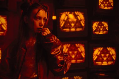 Tvs duvarına çağdaş spor kıyafeti giyen model ile cyberpunk tarzı çekim