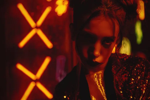 Cyberpunk estilo close-up com modelo vestindo roupão vermelho com glitter contra neon — Fotografia de Stock