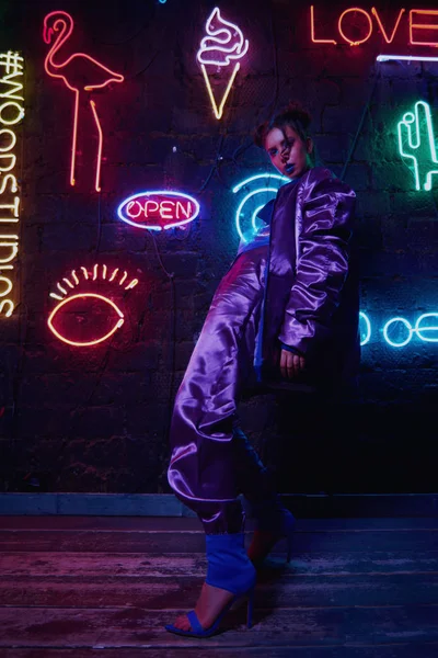 Cyberpunk tiro de modelo vestindo sportswear contemporânea contra a parede de néon — Fotografia de Stock