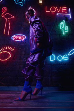 Neon duvar karşı çağdaş spor giyim giyen model cyberpunk çekim