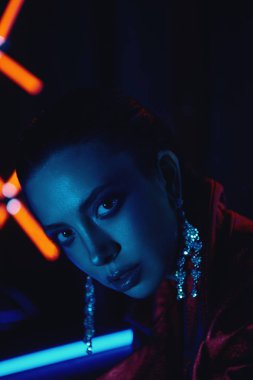 cyberpunk neon karşı deri kanepede oturan kırmızı bisikletçiler ceket giyen model yakın
