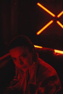 cyberpunk neon karşı deri kanepede oturan kırmızı bisikletçiler ceket giyen model yakın