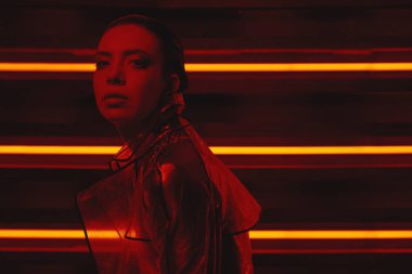 neon duvara karşı selofan ve kırmızı elbise şeffaf kat giyen model cyberpunk çekim