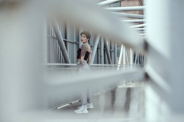 Köprüde poz veren dövmeli kuzgun saçlı genç bayan