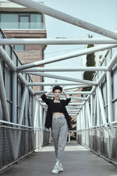 Raven haired jonge dame met tatoeages poseren op de brug — Stockfoto