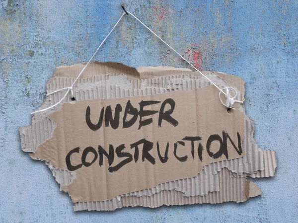 Construction Cardboard Sign Rope Ripped Corrugated Paper Hanging Cracked Wall — Stock Photo, Image