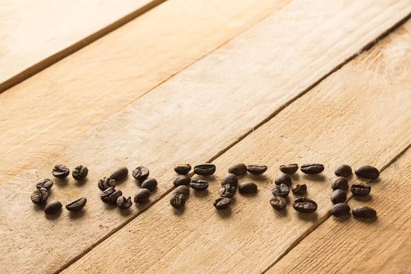 word coffee written by coffee beans on wooden background