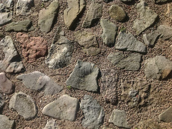 Stone pavement texture, granite cobblestoned pavement background, cobbled stone road regular shapes, abstract background of old cobblestone pavement close-up