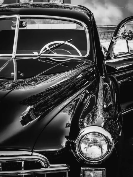 Monochrome picture. Retro car show. Black classic retro car. Vintage car fragment.