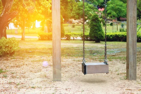 Odağı, bahçesi objektif parlama efektli boş ahşap salıncağa seçin