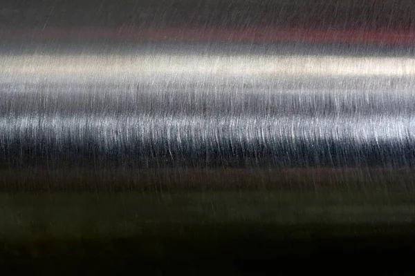 Texture of reflection on stainless steel pipe in dark room, abstract background