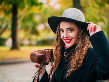 güzel kız bir palto ve şapka ile bir fotoğraf makinesi fotoğraf çekmek