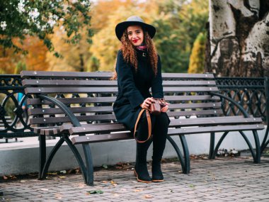 güzel kız bir palto ve şapka ile bir fotoğraf makinesi fotoğraf çekmek