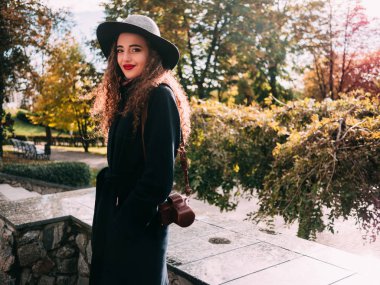 güzel kız bir palto ve şapka ile bir fotoğraf makinesi fotoğraf çekmek