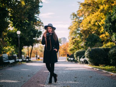 güzel kız bir palto ve şapka ile bir fotoğraf makinesi fotoğraf çekmek