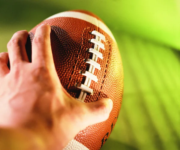 close up view of football ball in hand