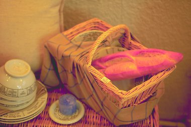 Tahta bir arka planda hasır sepet ve ekmek.