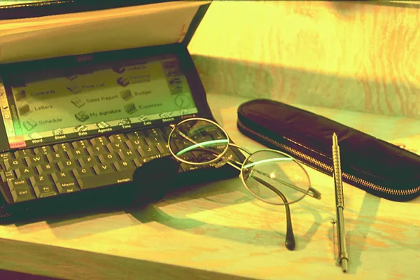 ノートとペンとグラスを木のテーブルの上に置き — ストック写真