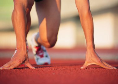 Genç adam pistte koşuyor.